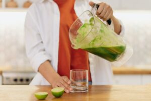 kobieta robi zielony sok w blenderze